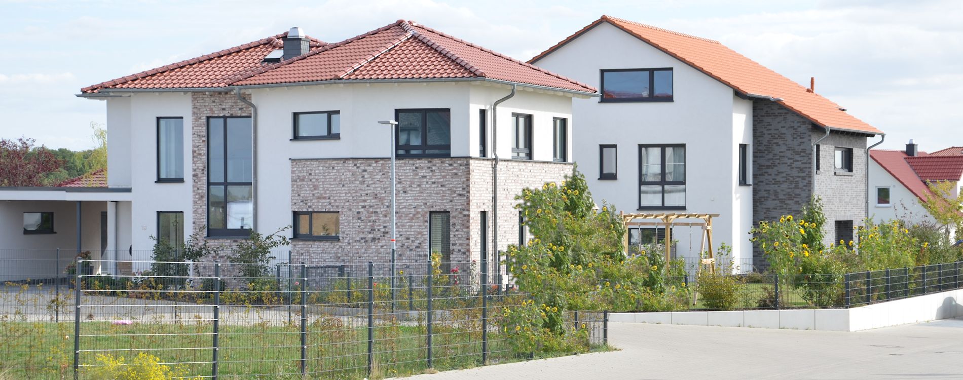 Moderne weiße Einfamilienhäuser mit Zeltdach